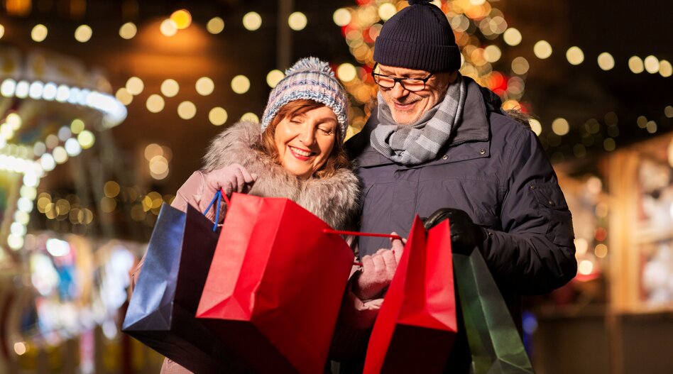 Europäische Metropolen zur Weihnachtszeit zum Christmasshopping mit railtour erleben. | © shutterstock / 1494691982 Glückliches Paar mit Einkaufstaschen am Weihnachtsmarkt nach erfolgreichem Weihnachtsshopping-Tag in der festlich geschmückten Stadt
| © shutterstock / 1494691982