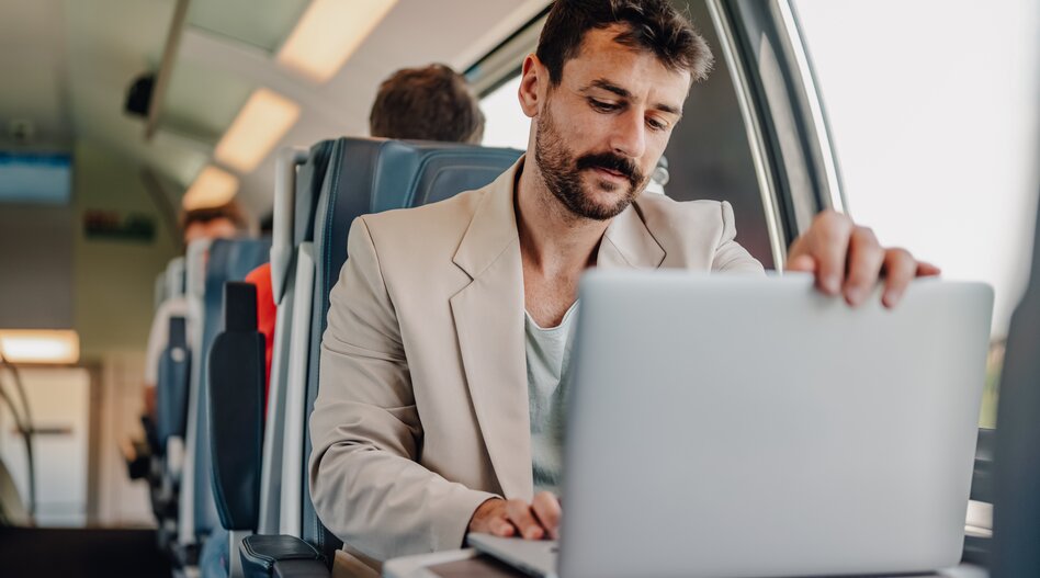 Junger Profi konzentrierte sich auf die Arbeit mit dem Laptop, während er mit dem Zug pendelte | © shutterstock_2700654093