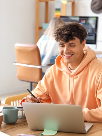 Graphiste travaillant à la table avec un ordinateur portable