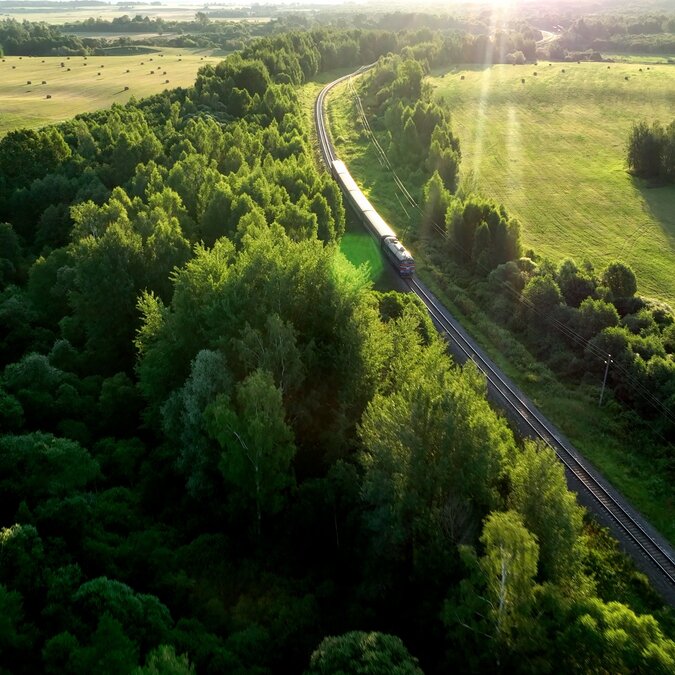 Zug fährt durch grüne Landschaft. 