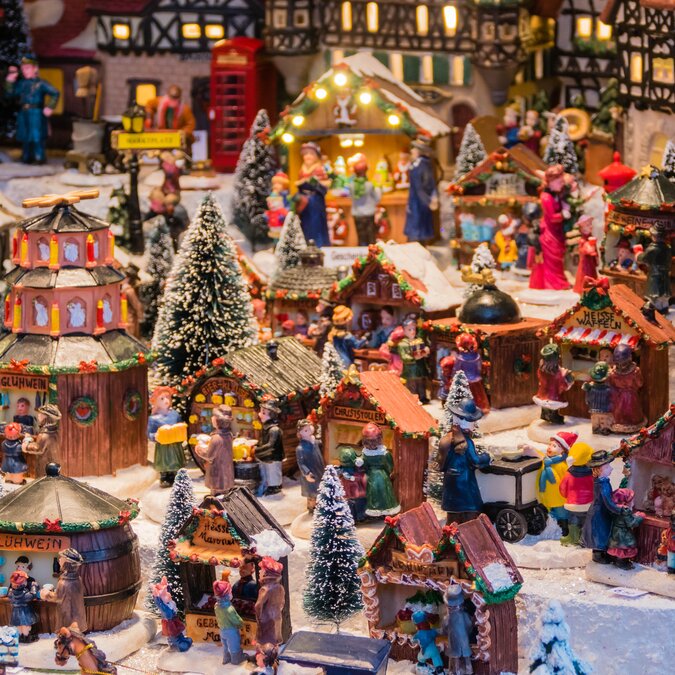 Kleine Windlichter in Form eines Dorfes auf einem Weihnachtsmarkt-Stand | © shutterstock / 2039899409