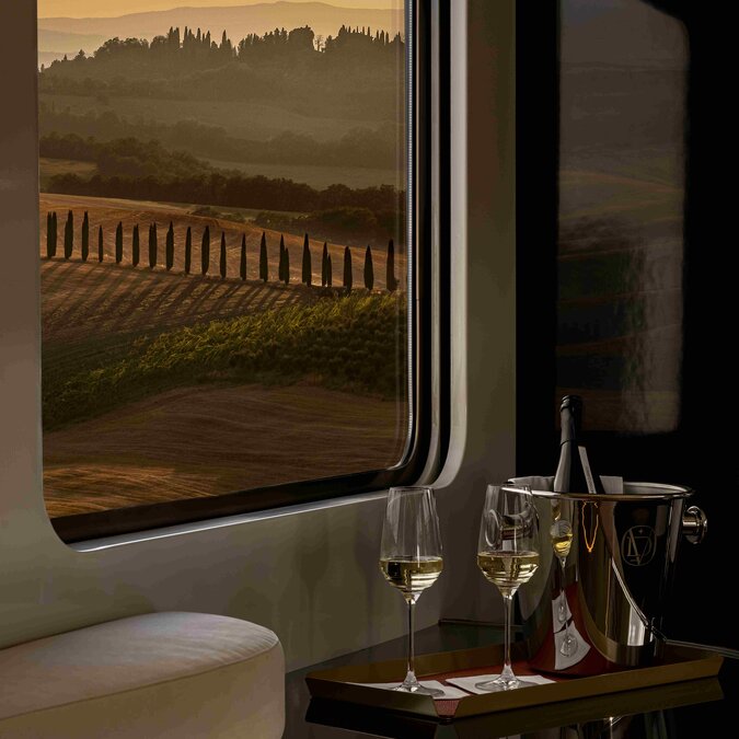 La Dolce Vita Orient Express - Bar car, seats with wine glasses and view on the countryside in Tuscany | © La Dolce Vita Orient Express