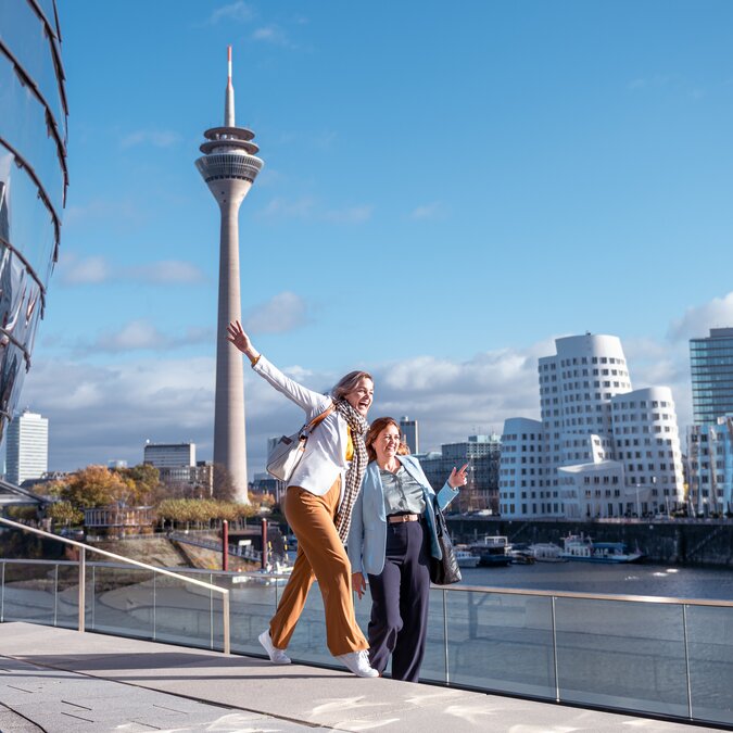 Zwei glückliche Personen posieren für ein Foto im Medien Hafen von Düsseldorf. | © Düsseldorf Tourismus