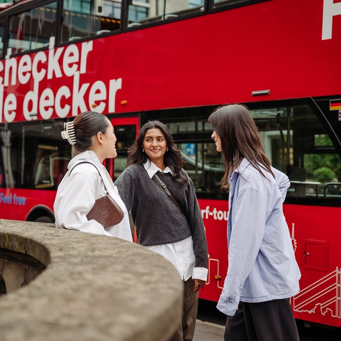 Drei junge Frauen vor einem Hop-On Hop-Off Bus in Düsseldorf. | © Düsseldorf Tourismus - React-EU