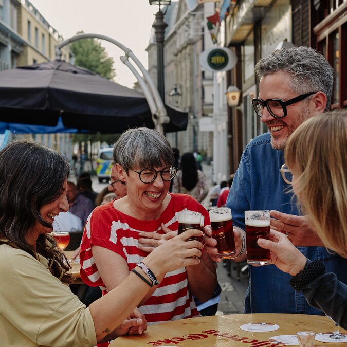 Des gens dans la vieille ville de Düsseldorf qui trinquent avec une bière.  | © Düsseldorf Marketing GmbH, Foto: Sabrina Weniger