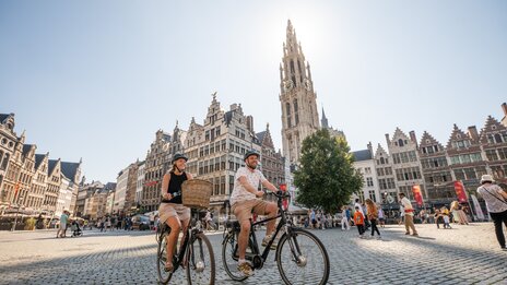Antwerpen Grote Markt: Velofahren zwischen flämischen Giebelhäusern und Kathedrale bei Sonnenschein | &copy; Piet de Kersgieter – Antwerpen Grote Markt