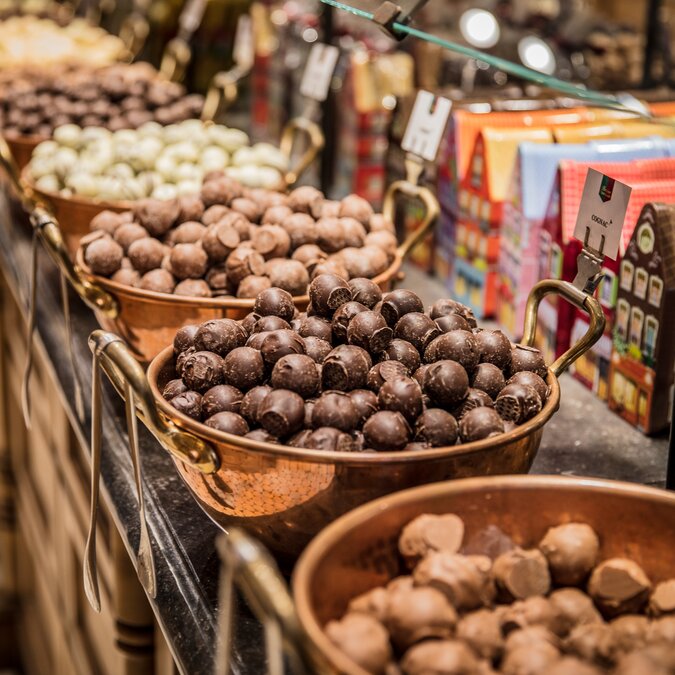 Chocolats belges et truffes dans des chaudrons en cuivre sur un comptoir à Bruges. | © Pieter D'Hoop – Chocolats de Bruges