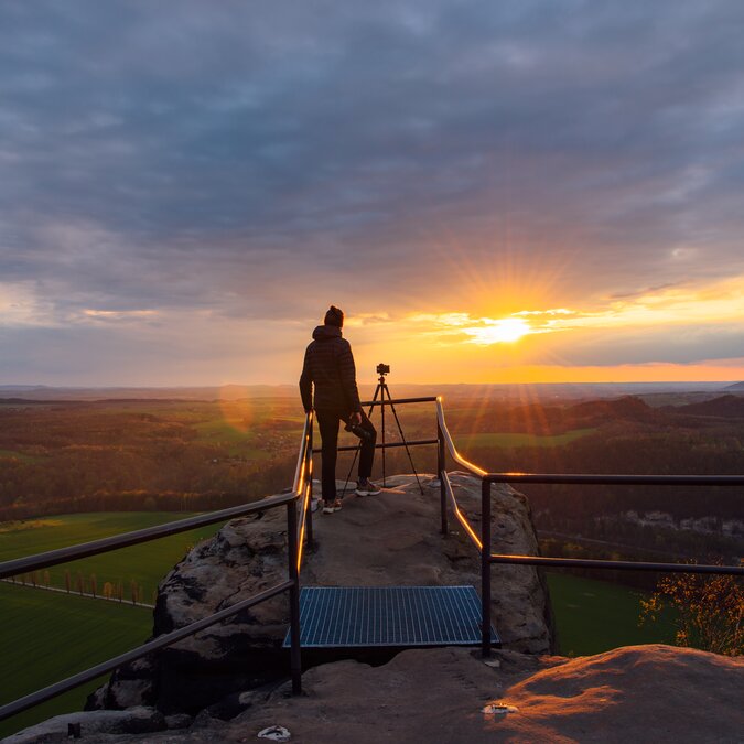Personne sur un belvédère face au paysage au coucher du soleil | © TMGS/CzechVibes