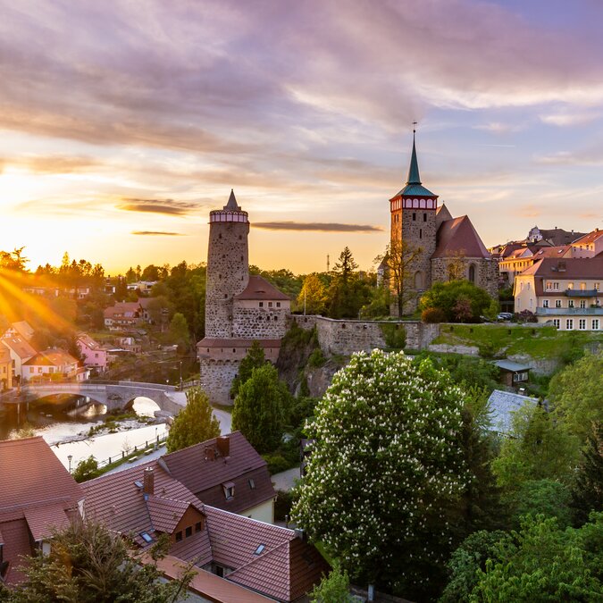 Ville historique avec tours et toits au coucher du soleil | © Sebastian Rose Fotografie