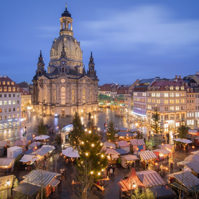 Blick über den festlich beleuchteten Dresdner Striezelmarkt auf dem Neumarkt mit der imposanten Frauenkirche im Hintergrund während der Adventszeit. | © Sebastian Rose Fotografie