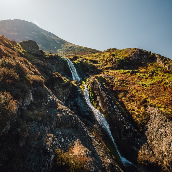 Cascade dans un paysage montagneux gallois avec une vallée rocheuse, des pentes verdoyantes et une eau claire au cœur d’une nature préservée. | © Crown Copyright (2026) Welsh Government
