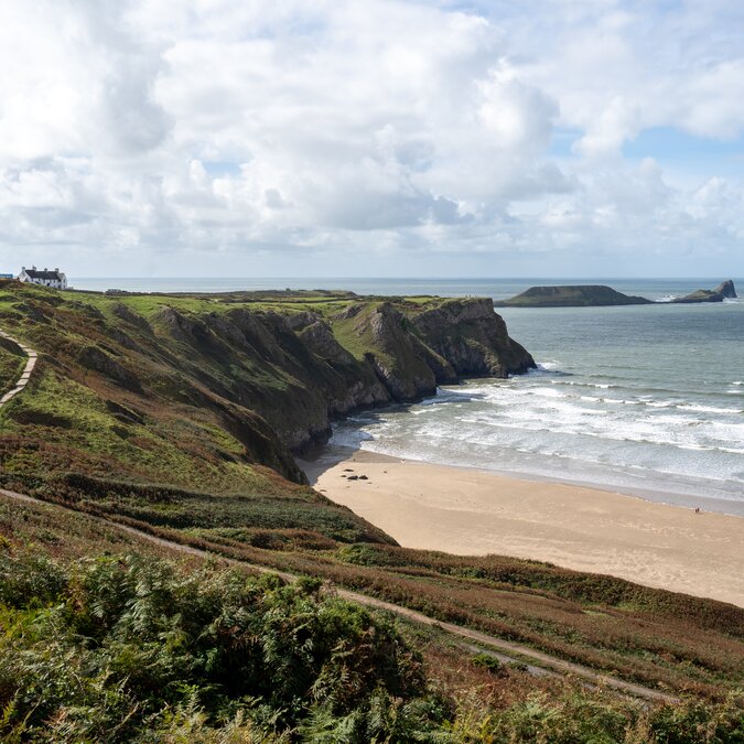 Strand Rhossili auf der Gezeiteninsel Worm's Head auf Wales | © Crown Copyright (2026) Welsh Government