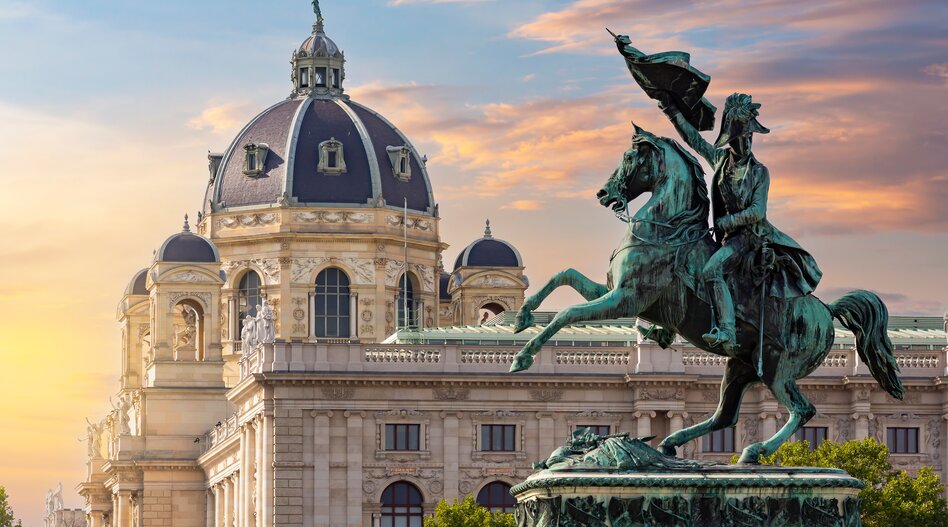 Statue des Erzherzogs Charles am Heldenplatz und Museum für Naturgeschichte bei Sonnenuntergang in Wien
 | © Shutterstock / 2193373789