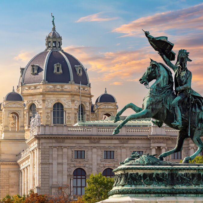 Statue des Erzherzogs Charles am Heldenplatz und Museum für Naturgeschichte bei Sonnenuntergang in Wien
 | © Shutterstock / 2193373789