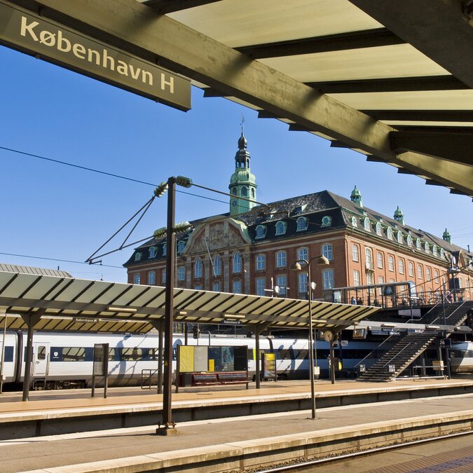 Bahnsteige des Kopenhagener Hauptbahnhofs (København H) mit historischem Bahnhofsgebäude im Hintergrund. | © shutterstock 63991135