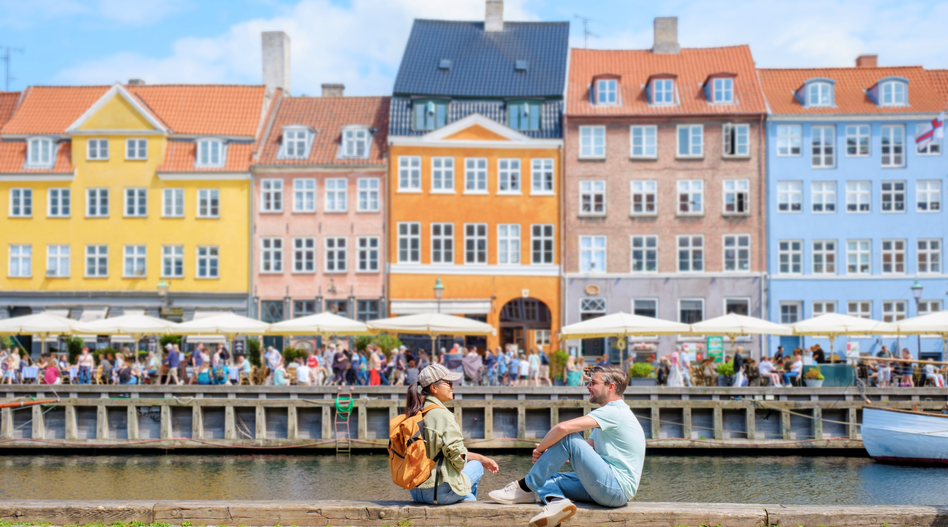 People by the canal in Copenhagen with colorful houses | © shutterstock_2492354477