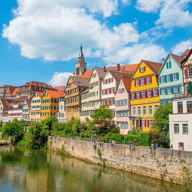 Tübingen in Stuttgart, Deutschland Farbiges Haus am Flussufer und blauer Himmel. Schöne alte Stadt in Europa. Leute sitzen an der Wand. | © Shutterstock 665140723