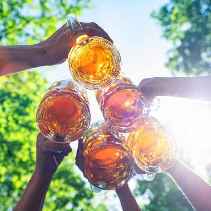 Cinq amis, hommes et femmes, qui s'amusent dans un Biergarten | © Shutterstock 2186512509