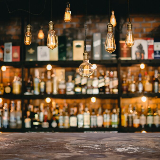 Metal table and vintage lamps with a liqueur bar background