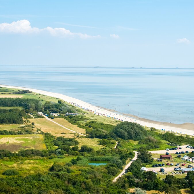 Luftansicht des Dörfchens Nieblum auf Föhr mit grünen Feldern, Häusern und der Nordseeküste. | © shutterstock / 2509201019