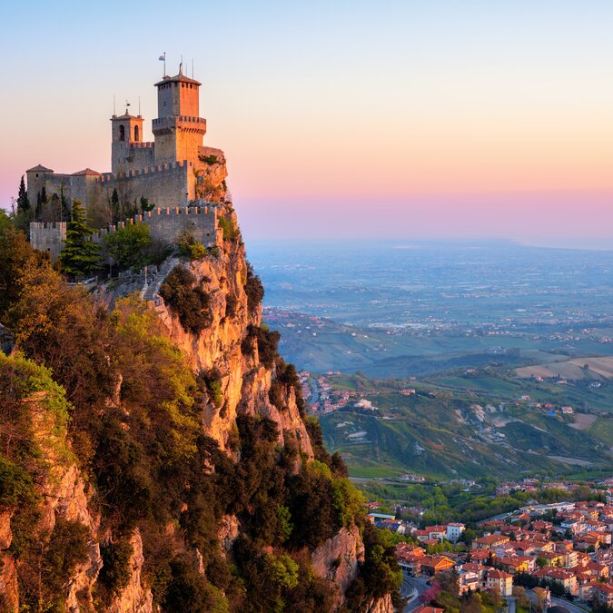 Forteresse perchée sur une falaise à Saint‑Marin avec vue sur le paysage environnant.
 | © shutterstock_1381614365