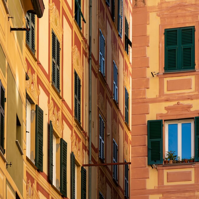 Yellow and orange coloured house facades in Camoglia | © shutterstock / 2463519515