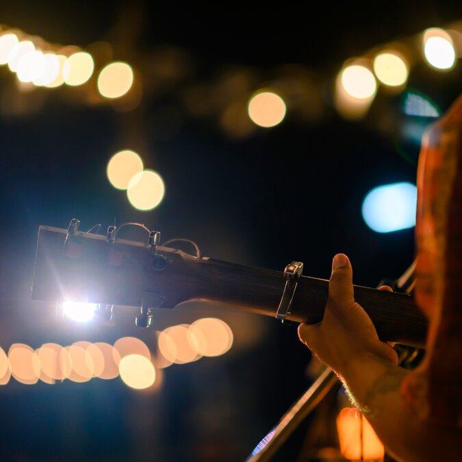 Guitar player from behind in atmospheric light | © shutterstock / 1505795255