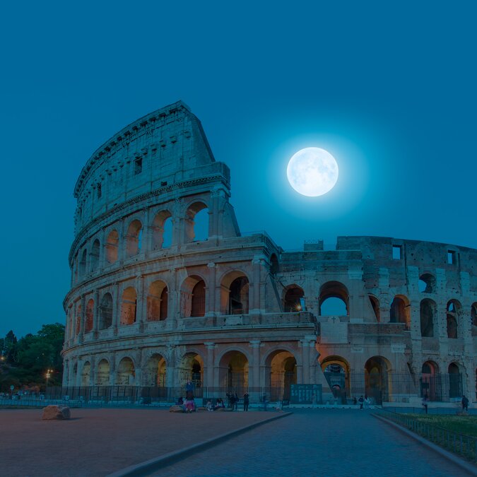 Colosseum in Rome at night with full moon . Colosseum is the most landmark in Rome "Elements of this image furnished by NASA | © Shutterstock 1449547847