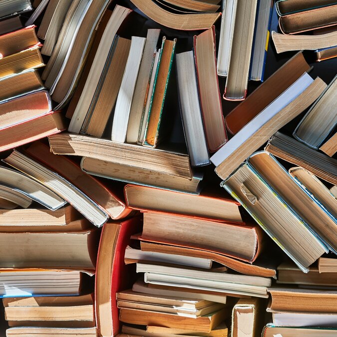 Pile alter Bücher in dramatisch dunklem Licht | © Shutterstock 1555865240