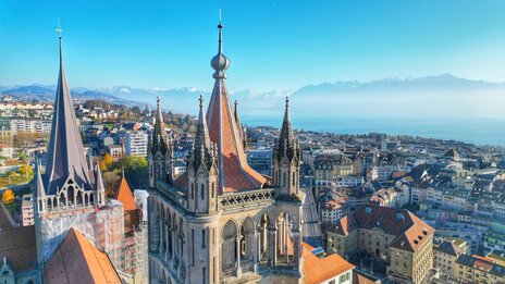 Blick über die Spitze der Kathedrale auf die darunterliegende Stadt und den Genfersee | © shutterstock / 2415664901