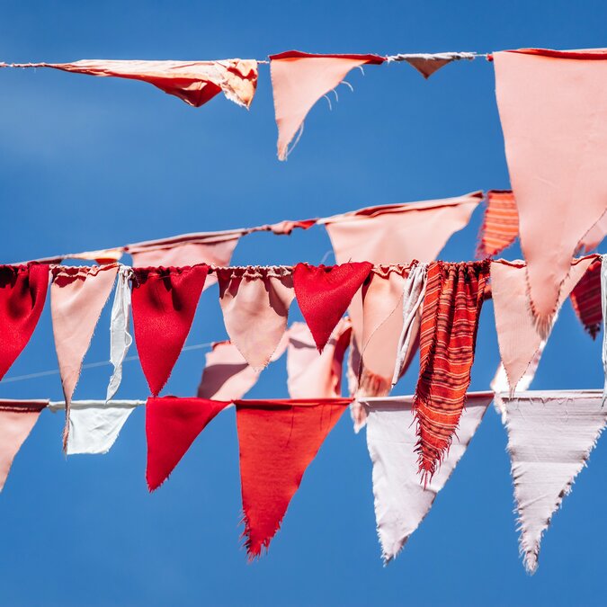 Des fanions colorés sur une corde au vent | © shutterstock / 2602576667